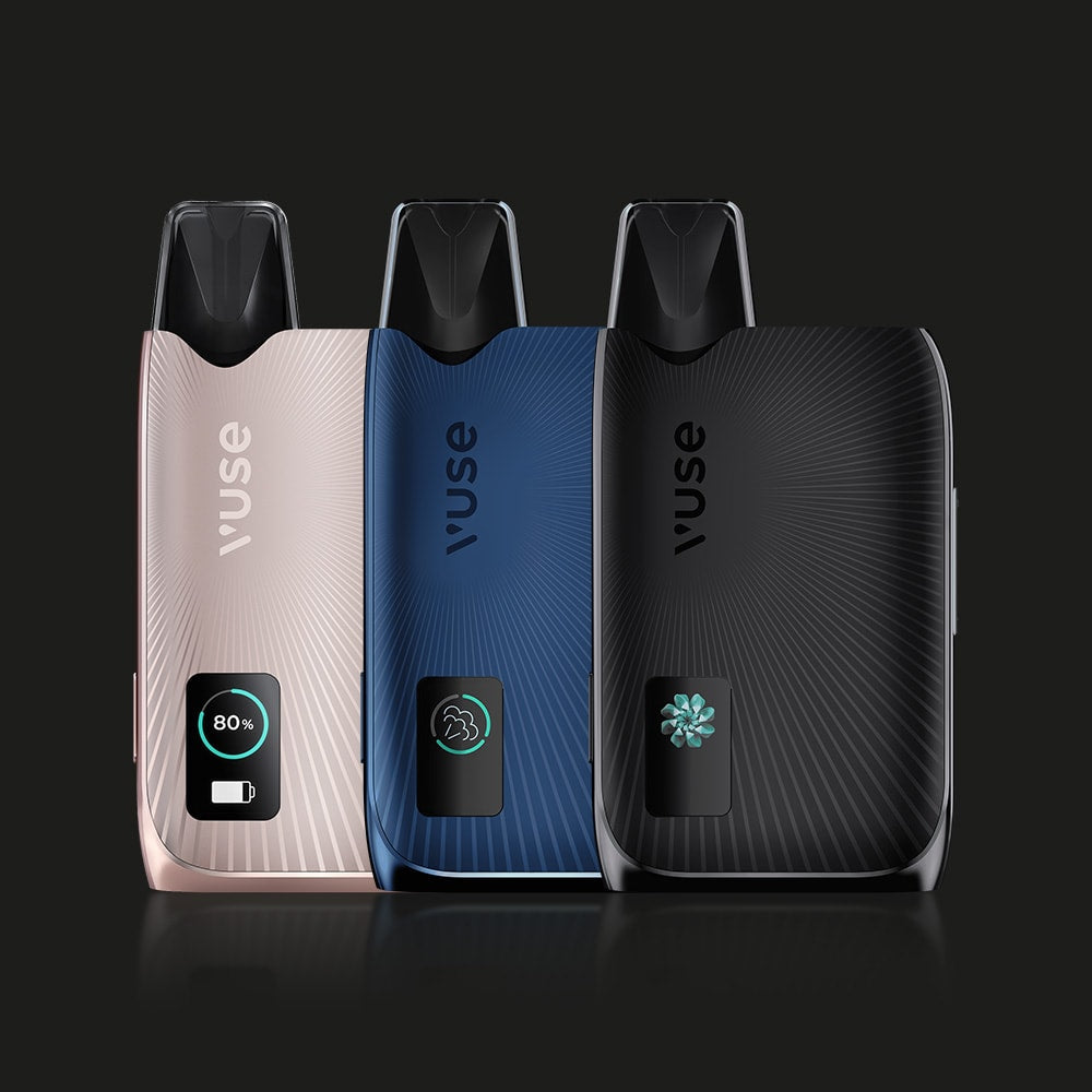 Vuse | Trois appareils « VUSE Ultra Kit Simple », aux couleurs or rose, bleu marine et noir, dotés chacun d'un boîtier en aluminium et d'un petit écran numérique, sont présentés debout sur un fond sombre à effet soleil. | Cigarettes Electroniques et Recharges
